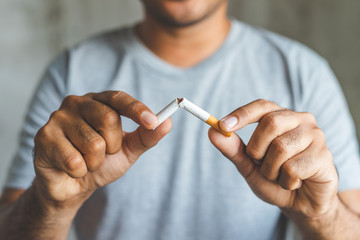 holding a broken cigarettes symbolizing stop smoking  